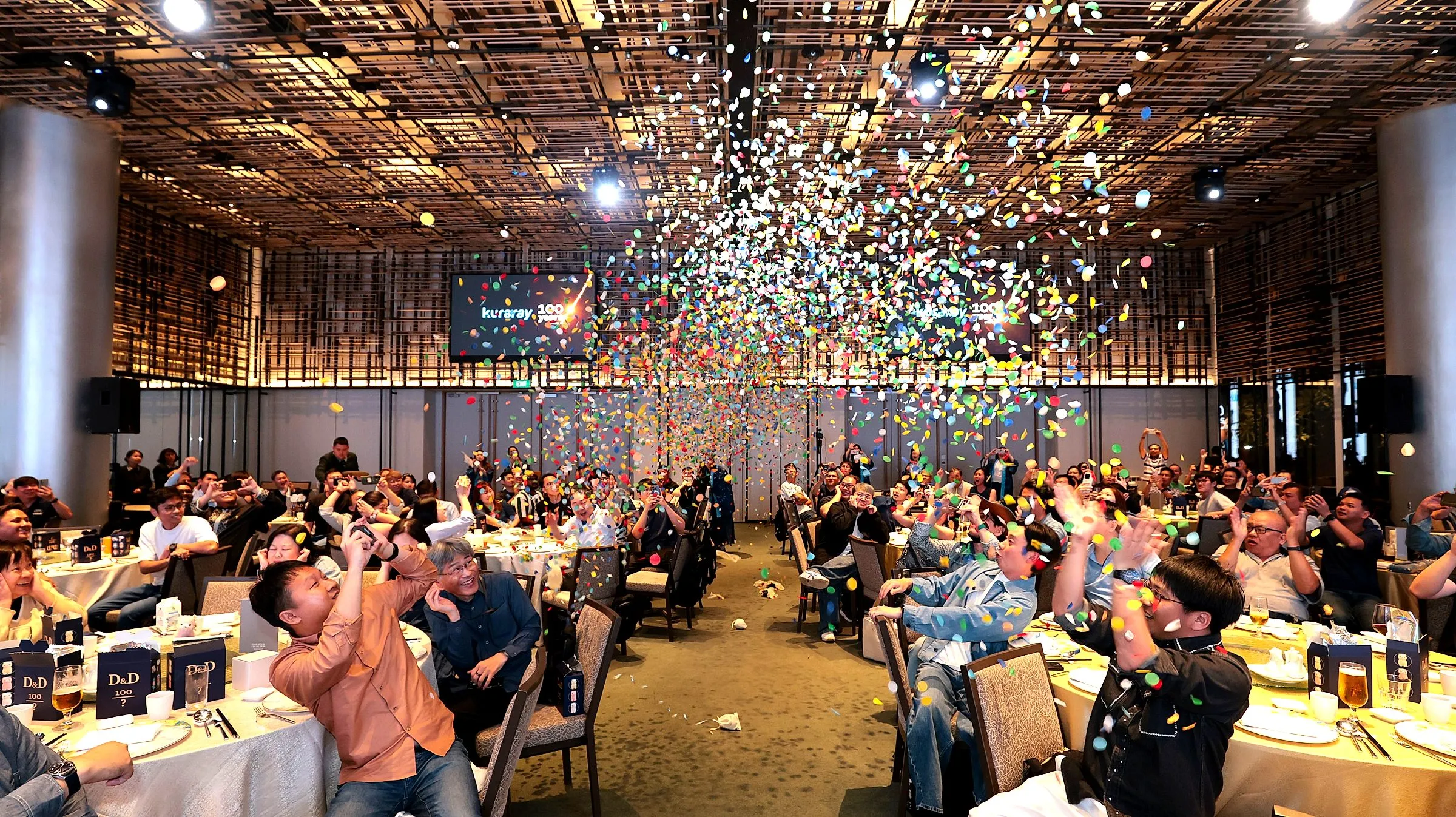 Confetti falling over a packed ballroom as guests look up